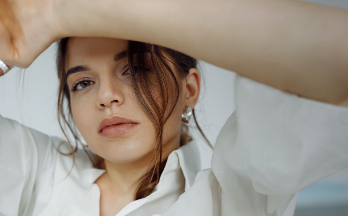 botox patient model in a white dress shirt with silver earrings